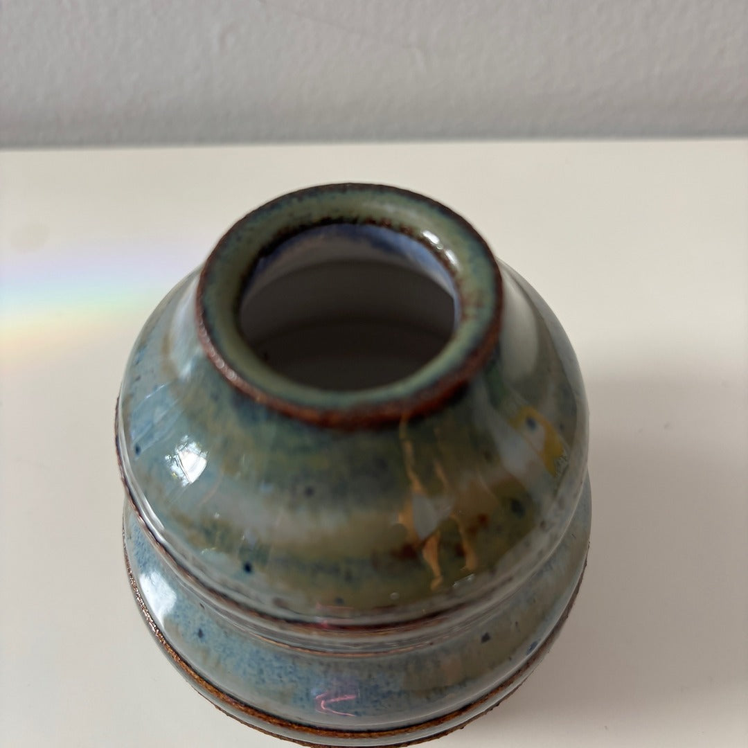 Ceramic vase with blue and brown glaze on a white background