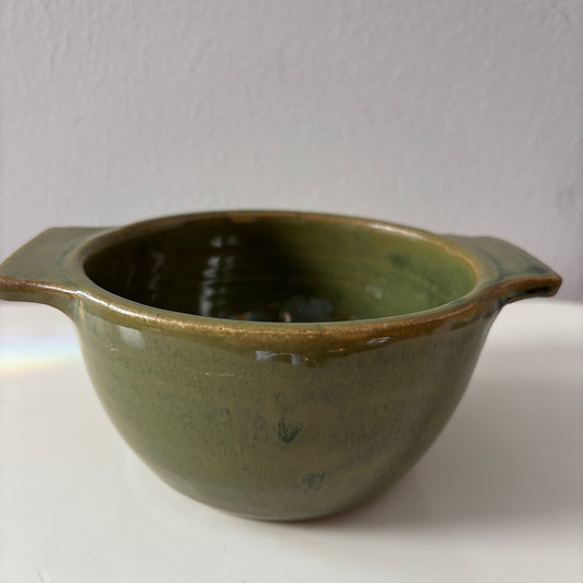 Green ceramic berry bowl on a white surface
