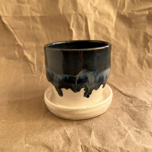 Midnight blue and white small handmade ceramic planter with integrated saucer on a crumpled brown paper background