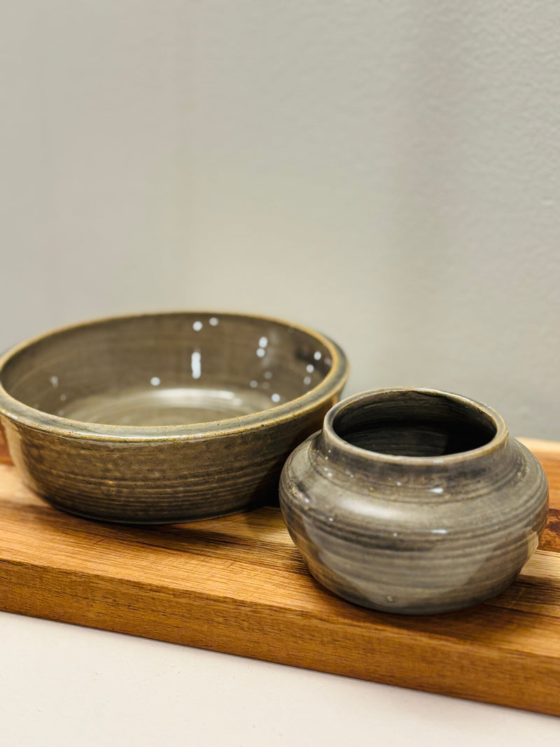 Two ceramic bowls on a wooden tray with a neutral background