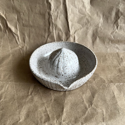 Speckled ceramic juicer on crumpled brown paper